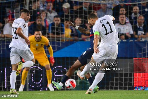 Bosnia-Herzegovina's forward Edin Dzeko shoots and scores a goal during the FIFA World Cup Qatar 2022 qualification Group D football match between...
