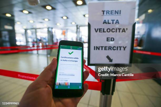 In this photo illustration a hand holding a smartphone with the positive result of the Green Pass verification, in the Naples train station. The...