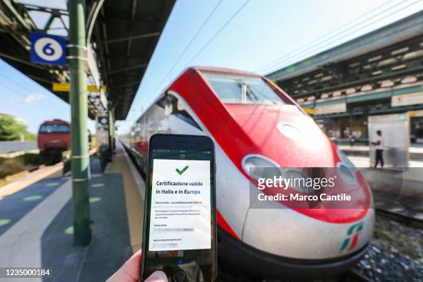 In this photo illustration a hand holding a smartphone with the positive result of the Green Pass verification, in Aversa train station. The Green...
