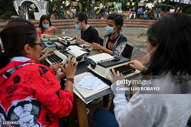 People write stories on a typewriter machine about university students and teachers affected by the armed conflict during a demonstration in Cali,...