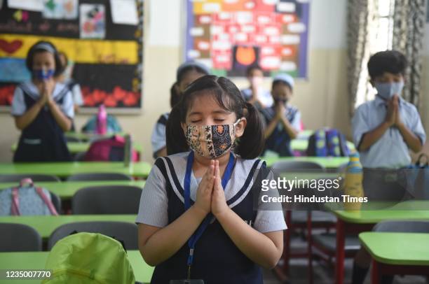 Young girl in a primary school classroom during the school prayer wears a facemask as offline teaching for Class 1st to Class 5th resumed across UP...