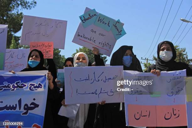 Afghan women hold placards as they take part in a protest in Herat on September 2, 2021. - Defiant Afghan women held a rare protest on September 2...