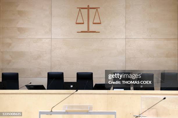 Picture taken on September 2, 2021 in Paris, shows the Justice symbol over judges seats at the temporary courtroom set up at the Palais de Justice of...