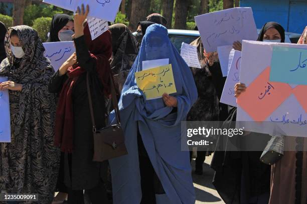 Afghan women hold placards as they take part in a protest in Herat on September 2, 2021. - Defiant Afghan women held a rare protest on September 2...