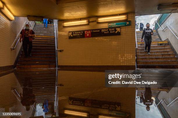 Commuters walk into a flooded 3rd Avenue / 149th st subway station and disrupted service due to extremely heavy rainfall from the remnants of...
