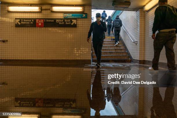 Commuters walk into a flooded 3rd Avenue / 149th st subway station and disrupted service due to extremely heavy rainfall from the remnants of...