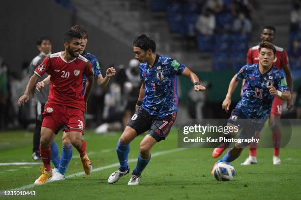 Salaah Said Al Yahyaei of Oman sends the pass under the pressure from Gaku Shibasaki of Japan during FIFA World Cup Asian Qualifier Final Round Group...