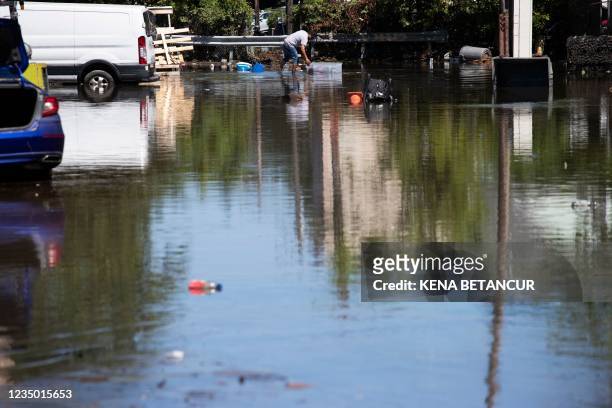 Man removes his belonging from a flooded street following a night of heavy wind and rain from the remnants of Hurricane Ida on September 02, 2021 in...