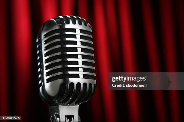 vintage microphone against a red curtain - old fashioned microphone stock pictures, royalty-free photos & images