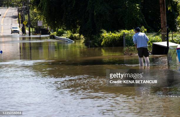 Man walks by a flooded street following a night of heavy wind and rain from the remnants of Hurricane Ida on September 02, 2021 in Mamaroneck, New...
