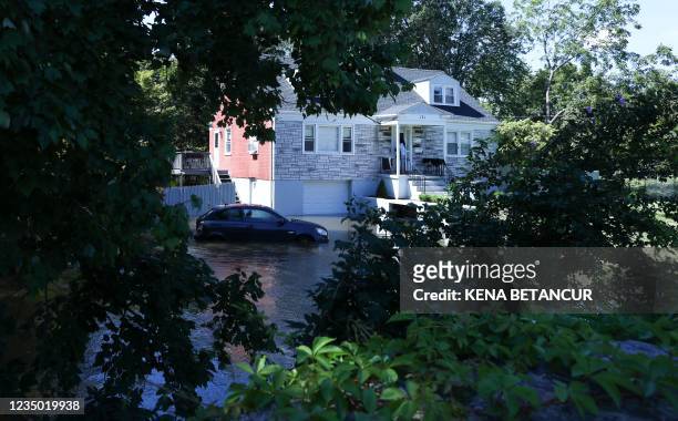 Car sits in a flooded parking spot in front of a house after a night of high winds and rain from the remnants of Hurricane Ida on September 2, 2021...