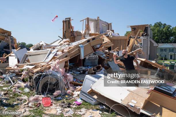 Sam Catrambone clears debris away from a friends home that was damaged by a tornado in Mullica Hill, New Jersey on September 2, 2021 after...