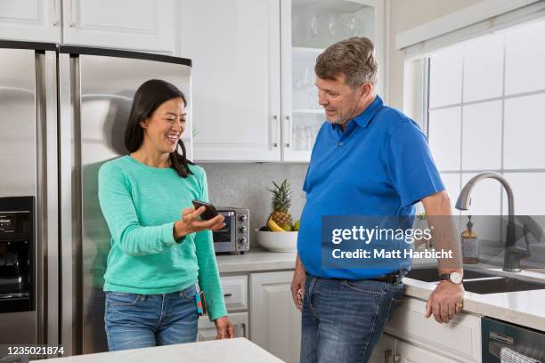 In this photo illustration, two casually-dressed people with type-1 diabetes wearing insulin pumps laugh at something on a smartphone.