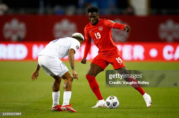 Alphonso Davies of Canada dribbles the ball against Andy Najar of Honduras during a 2022 World Cup Qualifying match at BMO Field on September 2, 2021...