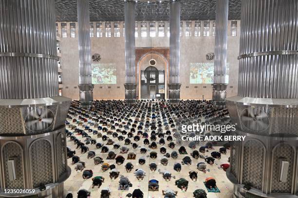 Muslim people conduct Friday prayers with physical distancing at the Istiqlal mosque in Jakarta on September 3, 2021.