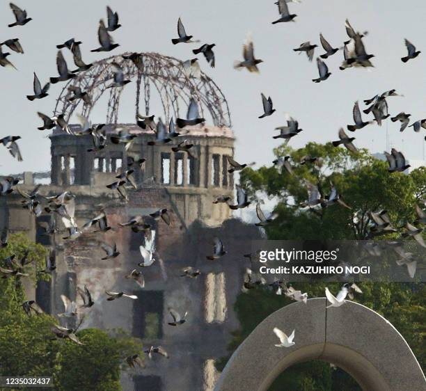 Doves fly over the cenotaph of the Atomic-bomb victims and the A-bomb Dome during the 58th annual memorial service for the two hundred thousands...