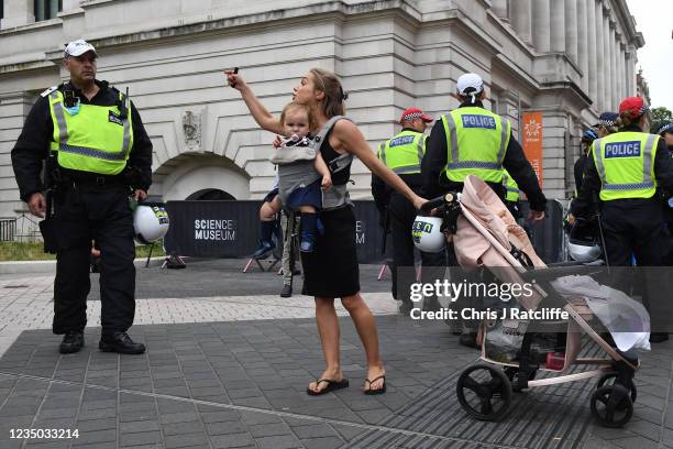 Woman carrying a baby argues with the police as she takes part in an anti-vaccination protest outside the Science museum on September 3, 2021 in...