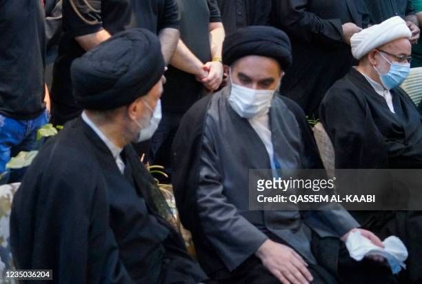 Mohammed Rida , son of Iraq's top Shiite cleric Grand Ayatollah Ali Sistani, comforts Mohammad Hussein, son of Ayatollah Mohammad Said al-Hakim, one...