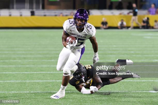 Keaton Mitchell running back of East Carolina runs through a hand grasp of Jackson Greene defensive back of Appalachian State during the Duke Mayo...