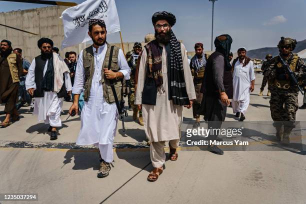 Anas Haqqani, center right, gets a tour of the military vehicles seized by Taliban fighters after the militant group seized the Hamid Karzai...