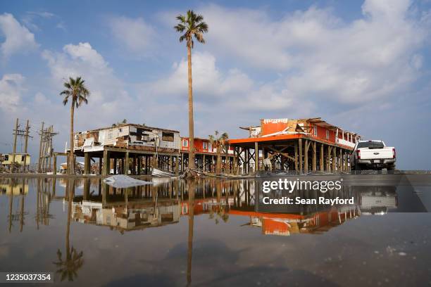 Storm damaged houses are reflected in flood water after Hurricane Ida on September 3, 2021 in Grand Isle, Louisiana. Ida made landfall as a Category...