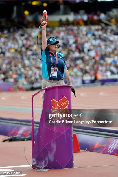 Female starter raises the gun before a heat in the women's 400 metres hurdles during day 7 of the 2012 Summer Olympics at the Olympic Stadium, Queen...