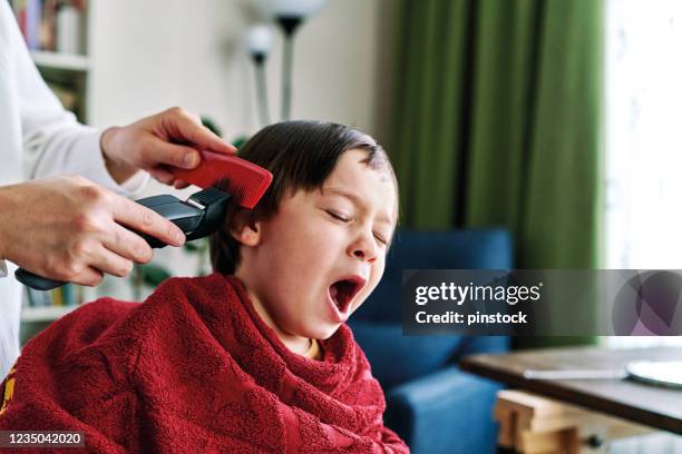 mother is cutting his son's hair at home. - lockdown haircut stock pictures, royalty-free photos & images