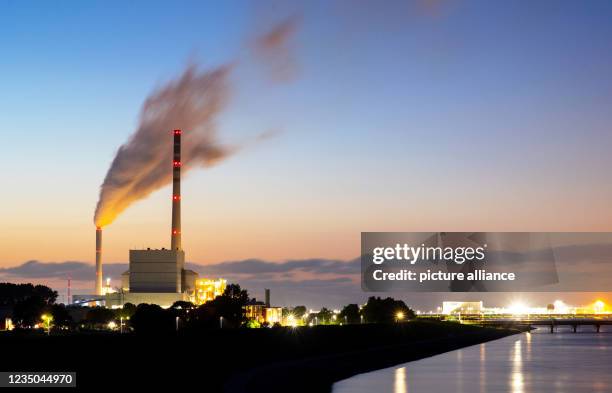 September 2021, Lower Saxony, Wilhelmshaven: The hard-coal-fired power plants of Onyx Power and Uniper Kraftwerke GmbH stand against the evening sky...