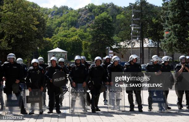 Police officers are seen in riot control gear while citizens of Montenegrin town of Cetinje gather at a baricade near the entrance of the city, on...