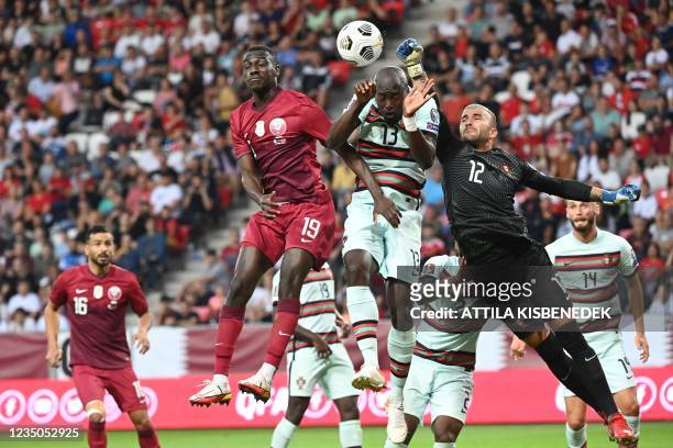Portugal's goalkeeper Anthony Lopes , Portugal's midfielder Danilo Pereira and Qatar's forward Almoez Ali vie for the ball during the friendly...