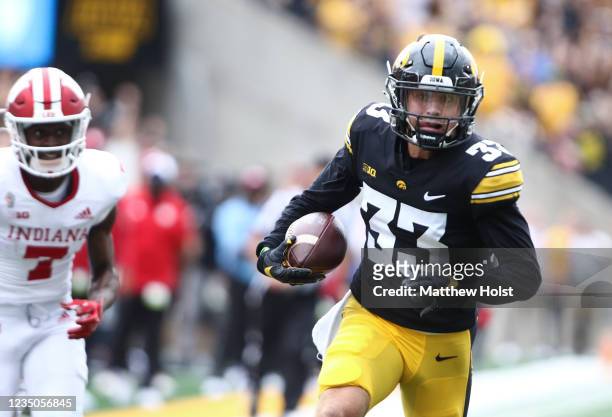 Defensive back Riley Moss of the Iowa Hawkeyes runs an interception in for a touchdown during the first half in front of wide receiver D.J. Matthews...