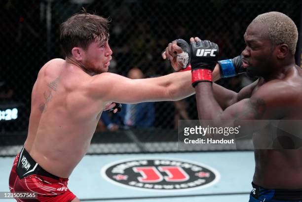 In this handout image provided by UFC, Darren Till of England punches Derek Brunson in their middleweight fight during the UFC Fight Night event at...