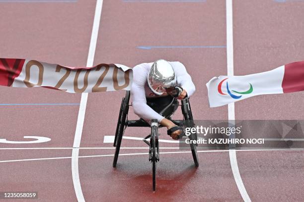 Switzerland's Marcel Hug crosses the finish line to win the men's marathon T54 athletics event during the Tokyo 2020 Paralympic Games at the Olympic...