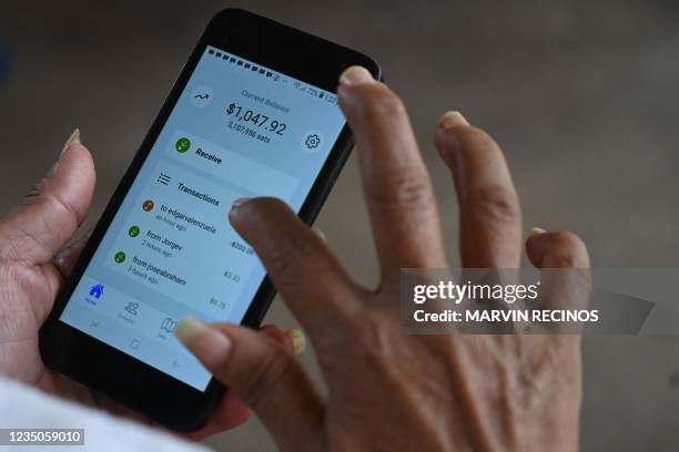 Woman uses the application of bitcoin at a store in El Zonte, La Libertad, El Salvador on September 4, 2021. - The Congress of El Salvador approved...