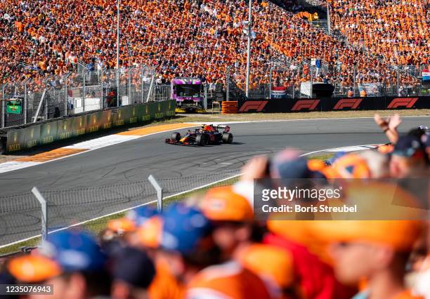 Fans celebrate Max Verstappen of the Netherlands driving the Red Bull Racing RB16B Honda during the F1 Grand Prix of The Netherlands at Circuit...