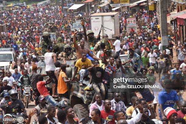 People celebrate in the streets with members of Guinea's armed forces after the arrest of Guinea's president, Alpha Conde, in a coup d'etat in...