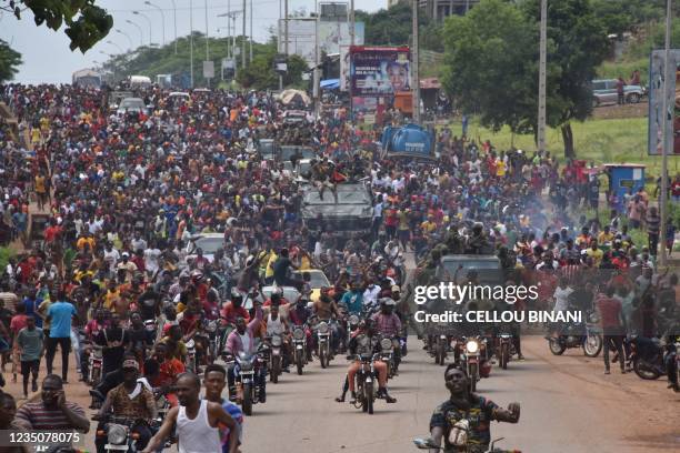 People celebrate in the streets with members of Guinea's armed forces after the arrest of Guinea's president, Alpha Conde, in a coup d'etat in...