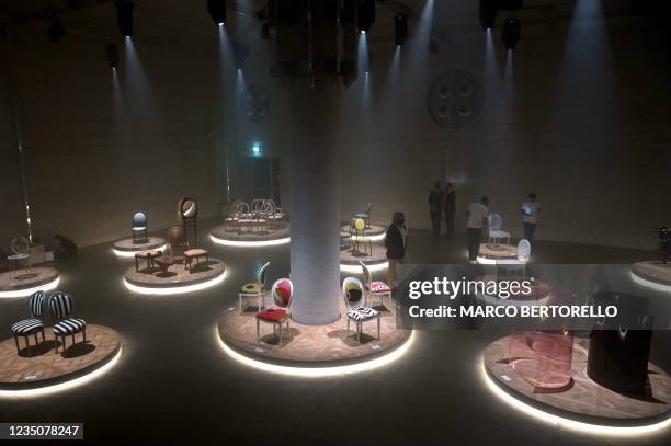 This picture taken on September 4, 2021 shows people looking at the Dior Medallion Chairs event displayed during the Fuorisalone 2021 design week in...