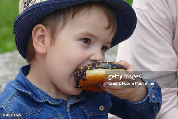 Boy bites at a doughnut during the Bread Festival 2021 in Ivano-Frankivsk, western Ukraine.