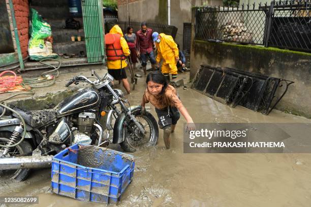 Girl walks through a street which was flooded after Bishnumati river overflowed following heavy monsoon rains in Kathmandu on September 6, 2021.