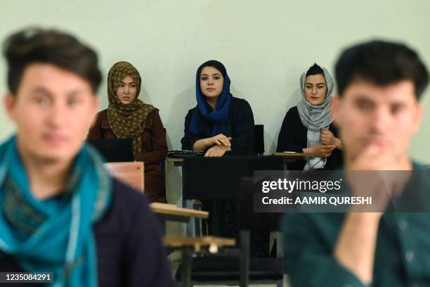 Students attend their class after private universities were reopened in Kabul on September 6, 2021. - Women attending private Afghan universities...