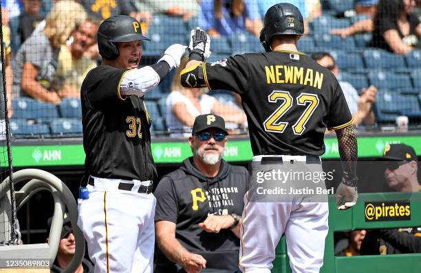 Kevin Newman of the Pittsburgh Pirates high fives with Yoshi Tsutsugo after hitting a two run home run in the first inning during the game against...