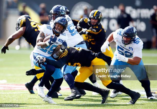 Foster of the Toronto Argonauts is tackled by Jovan Santos-Knox of the Hamilton Tiger-Cats during a CFL game at Tim Hortons Field on September 6,...