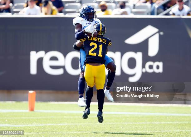 Llevi Noel of the Toronto Argonauts is tackled by Simoni Lawrence of the Hamilton Tiger-Cats during a CFL game at Tim Hortons Field on September 6,...