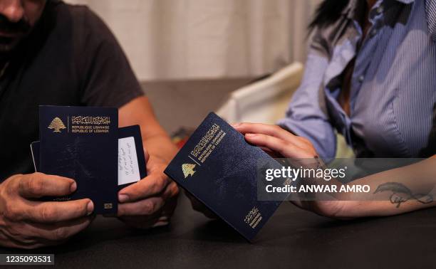 Nanor Abachian and her husband Shadi Abi Haidar look at their Lebanese passports at their home in Beirut's Naccache area, on August 31 as they...