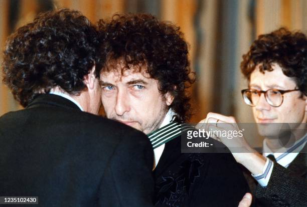 French Culture minister Jack Lang awards US singer Bob Dylan with knight of the Order of Arts and Letters on January 30, 1990 in Paris.