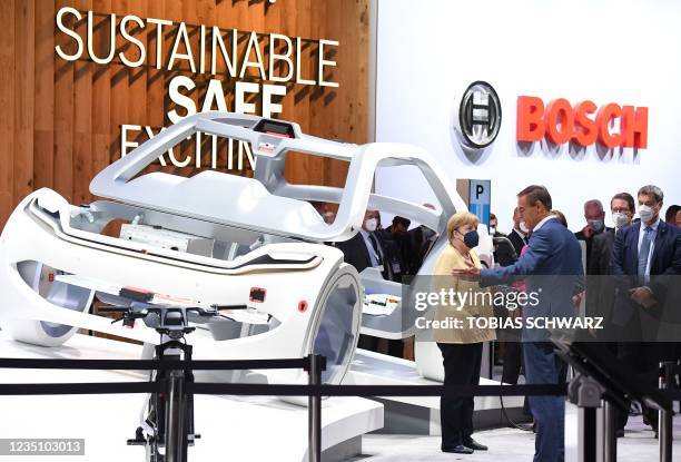 German Chancellor Angela Merkel visits the booth of Bosch company, as Volkmar Denner , CEO of Bosch, speaks during a presentation at the...