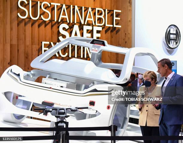 Of Bosch Volkmar Denner speaks to German Chancellor Angela Merkel during her visit at the company's booth at the International Motor Show Germany, on...