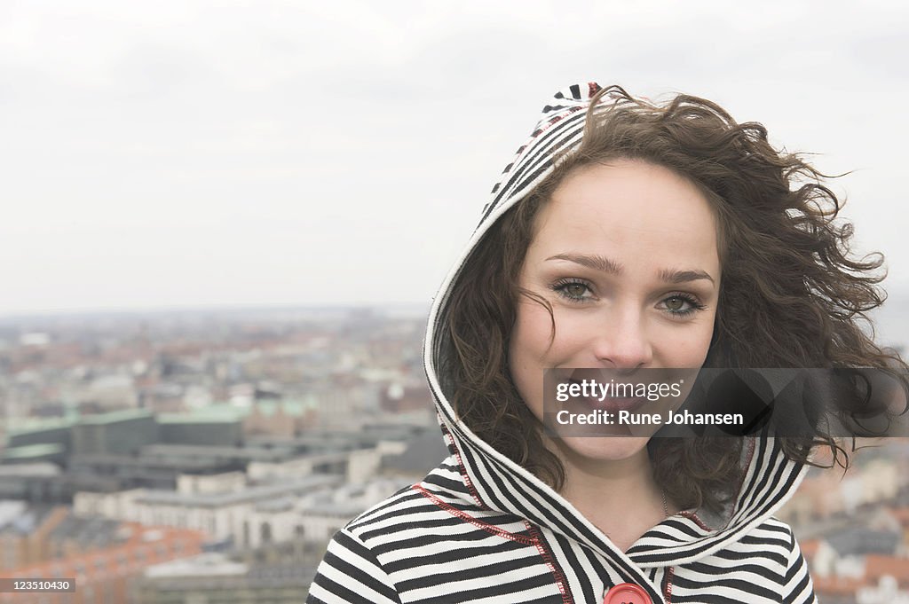 Portrait of a young Danish woman, 26 years old, outdoors in a black and white striped hooded sweater, Copenhagen, Denmark
