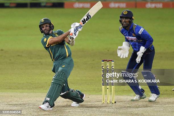 South Africa's Keshav Maharaj plays a shot as Sri Lanka's wicketkeeper Dinesh Chandimal looks on during the third one-day international cricket match...